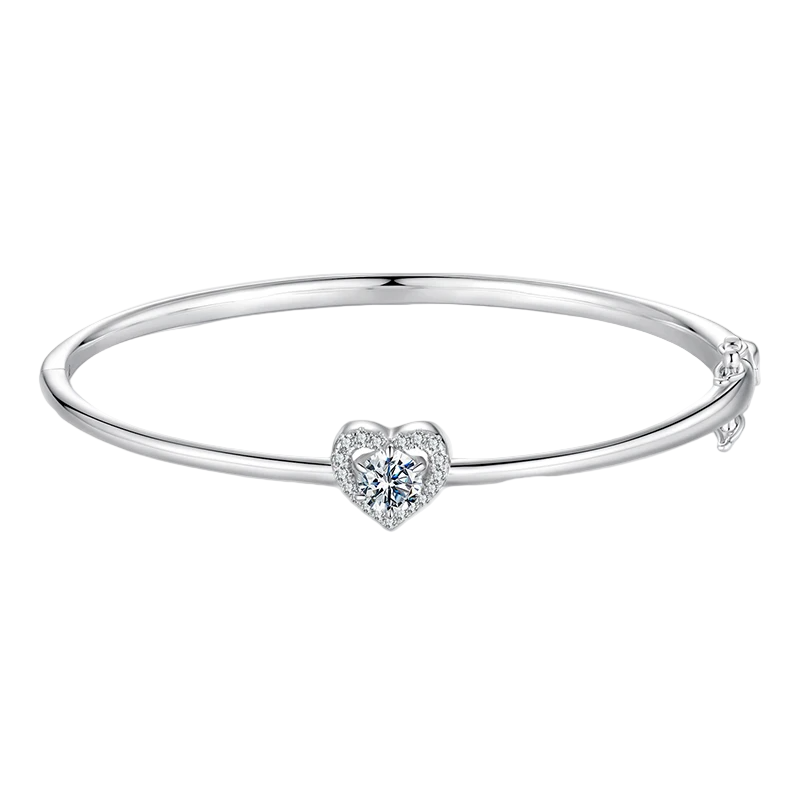 Silver bangle with a heart-shaped diamond on a white background