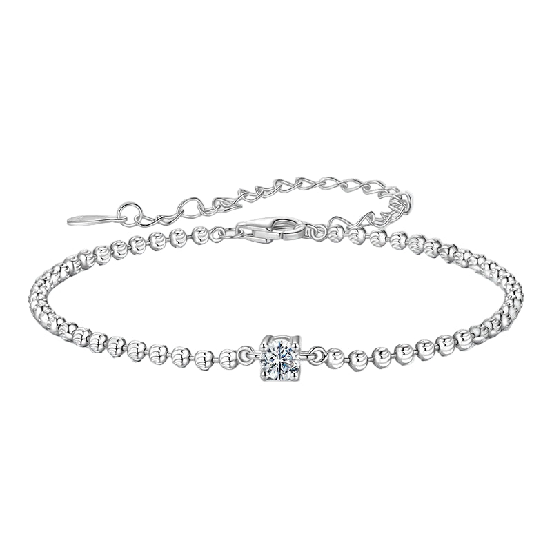 Silver bracelet with a small cross charm on a white background